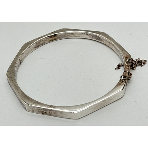 1121 - A silver Octagonal shaped hinged bracelet with safety chain and clip clasp. Stamped 925 on clasp. Sa... 