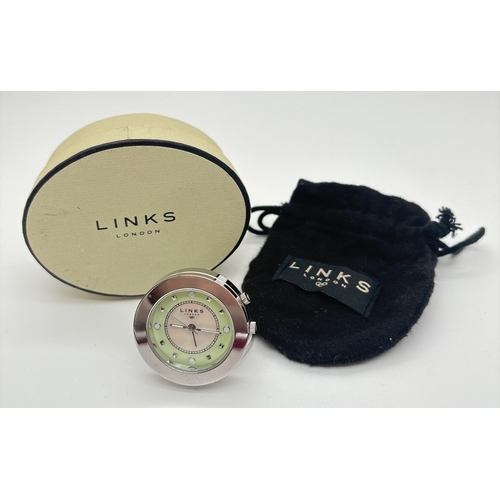 1223 - A small circular travel alarm clock by Links Of London. Stainless steel silver finish case and fixed... 