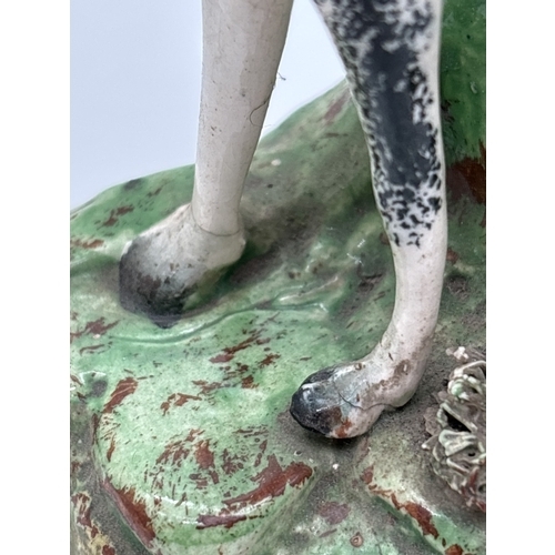 1229 - 3 Staffordshire 19th century figures. A sponge finished black and white horse spill vase, a flat bac... 