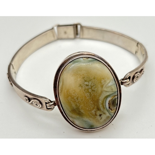 1003 - A modern design silver bracelet with 4 hinged links & a large green agate cabochon. Scroll decoratio... 