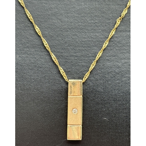 1050 - A 9ct gold modern design drop pendant set with a small round cut diamond, on an 18