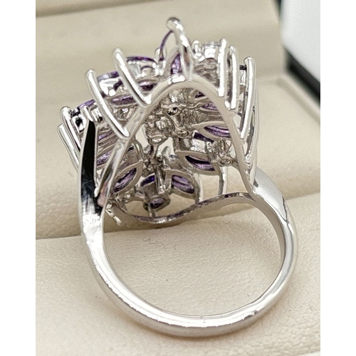 1093 - A large rhodium plated costume jewellery cocktail ring set with Swarovski crystals. A large floral d... 