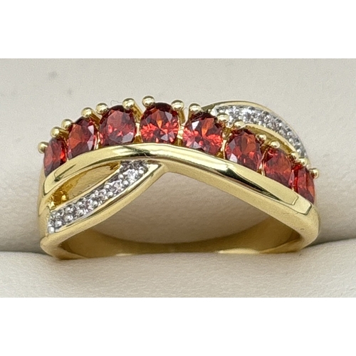 1098 - A yellow gold plated crossover cocktail ring set with round cut red and clear Swarovski crystals. 8 ... 