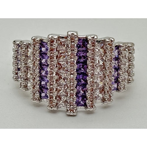 1099 - A rhodium plated cathedral style cocktail ring set with alternating rows of purple & clear Swarovski... 