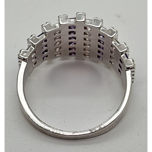 1099 - A rhodium plated cathedral style cocktail ring set with alternating rows of purple & clear Swarovski... 