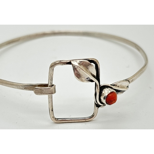 1114 - An Art Nouveau inspired Polish .800 silver bangle set with coral. Large square hook and eye clasp de... 