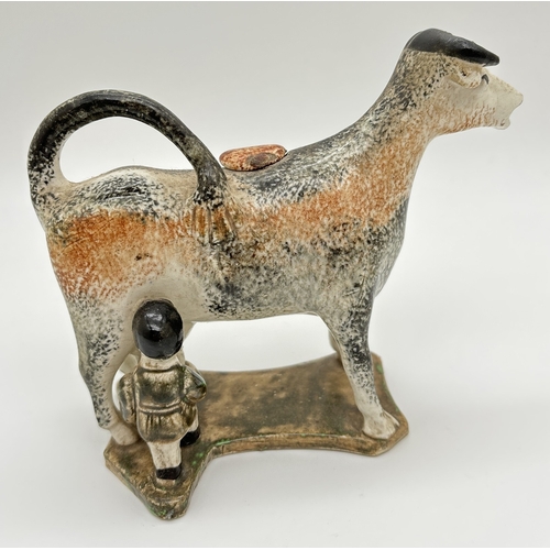 1226 - An Antique Pratt ware creamer in the shape of a cow being milked by a milkmaid. Complete with stoppe... 