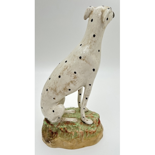 1231 - 2 19th century Staffordshire dog figures. A spotted dalmatian on a naturalistic style base together ... 