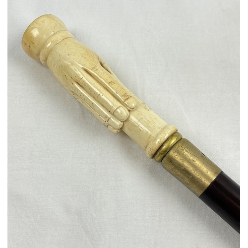 1365 - An ebonised walking cane with carved bone handle modelled as a hand and set with a compass. Approx. ... 