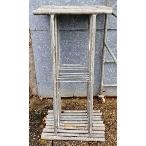 1399 - A galvanised steel scaffold tower with wheels and platform boards. 1.3 x 1.3m square. Minimum platfo... 