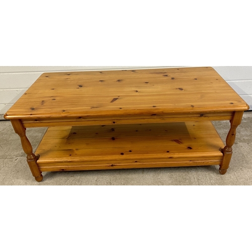 1419 - A honey pine coffee table with under shelf and turned legs. Approx. 44 x 106cm.