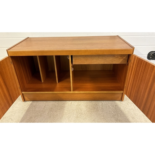 1421 - A retro teak wood low 2 door storage unit with interior sectional compartments and drawer. On caster... 