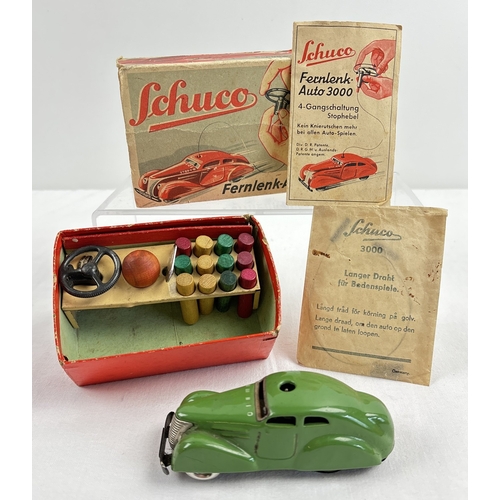 A Schuco boxed Vintage German tinplate Telesteering remote control Fernlenk-Auto 3000 car in green. Box contains tinplate car, remote wire in bag, steering wheel, skittles, wooden ball winding key and leaflet. Car approx. 10.5cm long.