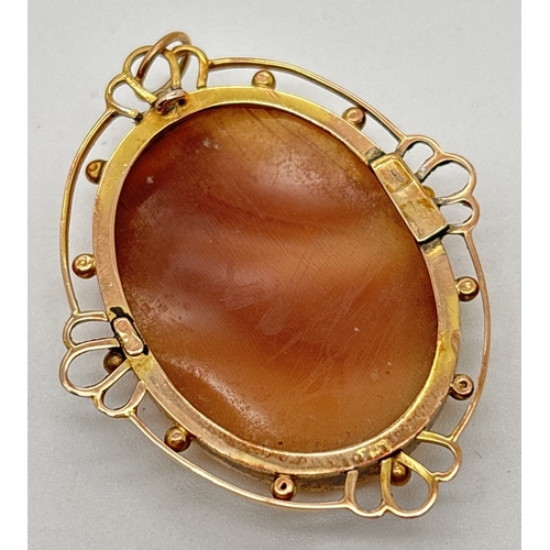 1011 - An antique oval shaped cameo pendant in a decorative open work mount with bead detail. 9ct stamped o... 