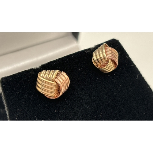 1019 - A pair of duo coloured yellow and rose gold knot style stud earrings. Unmarked but test as 9ct. Tota... 