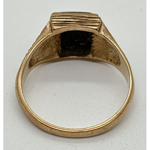 1020 - A vintage 9ct gold and black onyx square set signet ring with ridged detail to mount and shoulders. ... 