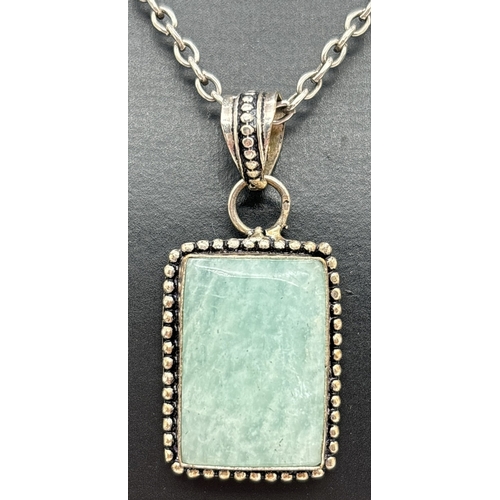 1033 - A modern design silver pendant necklace set with a square cut aquamarine stone. On a 24