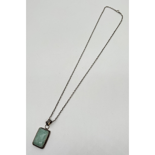 1033 - A modern design silver pendant necklace set with a square cut aquamarine stone. On a 24