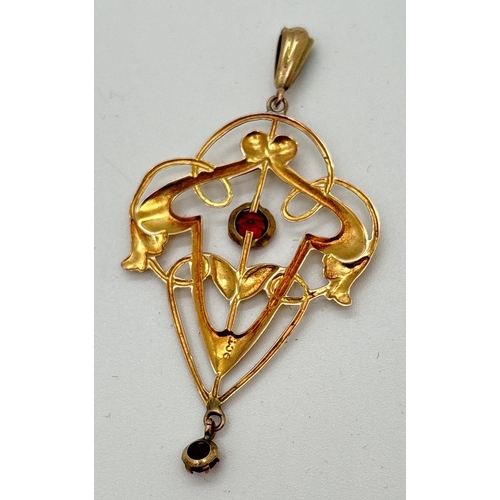 1007 - A 9ct gold Art Nouveau style floral open work pendant with red stone drop and central stone. Marked ... 