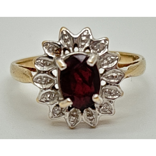 1041 - A 9ct gold garnet & diamond cluster ring with central oval cut garnet and 4 small round cut diamonds... 