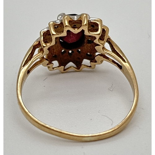 1041 - A 9ct gold garnet & diamond cluster ring with central oval cut garnet and 4 small round cut diamonds... 