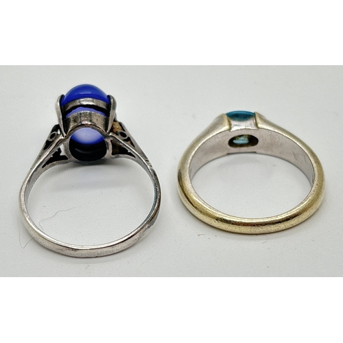 1043 - 2 silver single stone set dress rings. A modern design ring tension set with an oval cut Swiss blue ... 