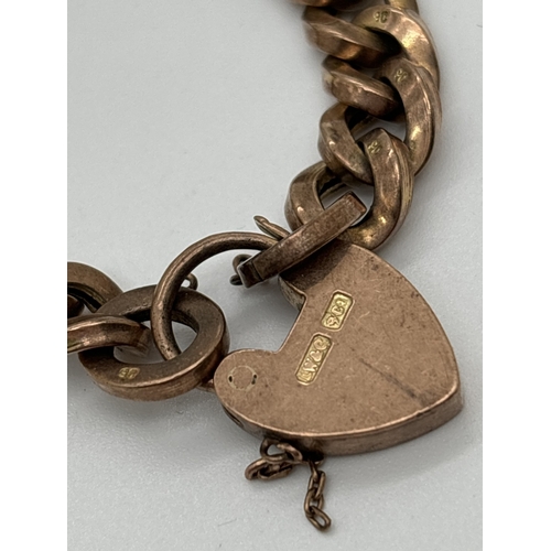 1046 - A vintage 9ct gold curb chain bracelet with heart shaped padlock clasp. Has remains of a safety chai... 