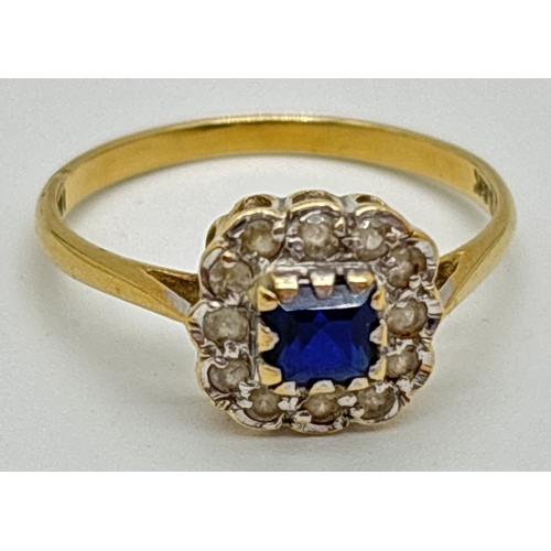 An 18ct yellow gold, sapphire and diamond square set dress ring. A Central square cut sapphire surrounded by 12 round cut diamonds. Makers initials and 18ct stamped inside of band. Size O, total weight approx. 2.3g.