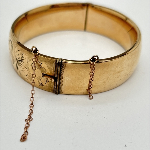 1061 - A vintage 1/5th 9ct gold metal core bangle with half engraved detail of scroll & foliate design. Pus... 