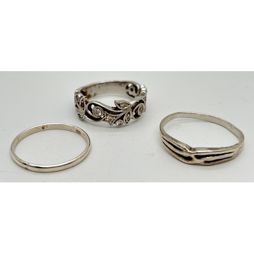 1069 - 3 silver band style rings. A large plain band, a cross over design and a half floral pierced work ba... 