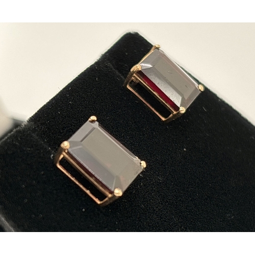 1074 - A pair of large square cut garnet stud earrings with gold mounts & posts. Each stone approx. 12 x 8m... 