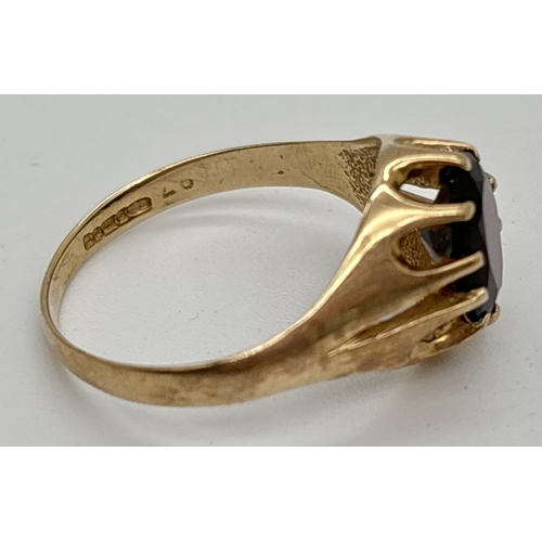 1009 - A 9ct yellow gold signet ring, claw set with an oval cut garnet. Hallmarked inside band. Ring size R... 