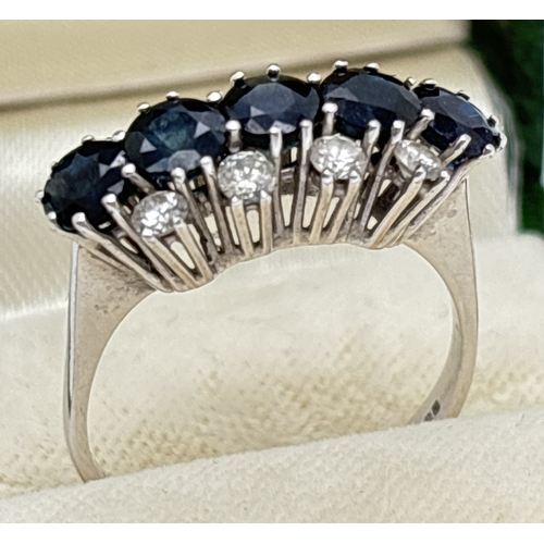 1078 - A vintage 18ct white gold, sapphire and diamond ring. A row of 5 round cut sapphires flanked by a ro... 