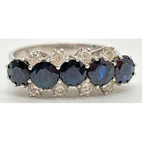 1078 - A vintage 18ct white gold, sapphire and diamond ring. A row of 5 round cut sapphires flanked by a ro... 