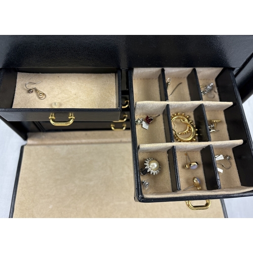 1090 - A large faux leather jewellery box with contents. Jewellery box has ring compartments, 5 pull out tr... 