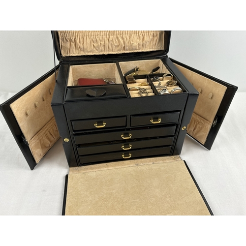 1090 - A large faux leather jewellery box with contents. Jewellery box has ring compartments, 5 pull out tr... 