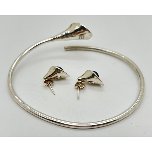 1001 - A 925 silver bangle and matching pair of stud earrings with Arum lily design each set with a peacock... 