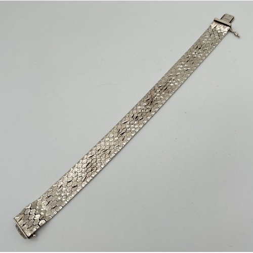 1094 - A vintage silver 7.5 inch heavy honeycomb flat link bracelet with floral engraved design to one side... 