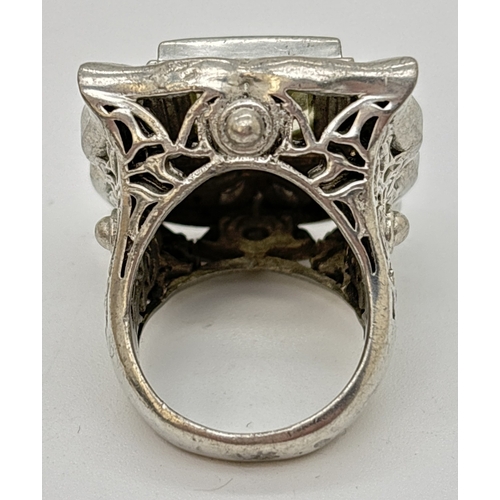 1110 - A large silver statement cocktail ring set with a square cut peridot. Fluted edge square mount with ... 