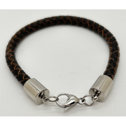 1116 - A brown leather plaited men's bracelet with silver tone hardware and lobster claw clasp. By Simon Ca... 