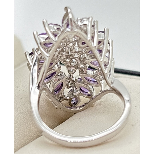 1121 - A large floral design statement cocktail ring in a rhodium plated finish, set with Swarovski crystal... 