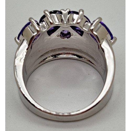 1125 - A thick band style cocktail ring set with 5 rows of clear, 4 pear cut purple and 1 round cut purple ... 