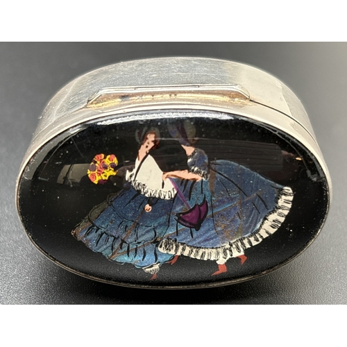 1213 - A George V oval shaped silver and butterfly wing trinket/pill box with crinoline lady design . Hallm... 