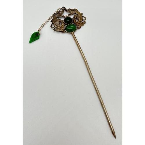 1145 - A Chinese white metal hair pin set with apple green jade cabochons. Approx. 17cm long.