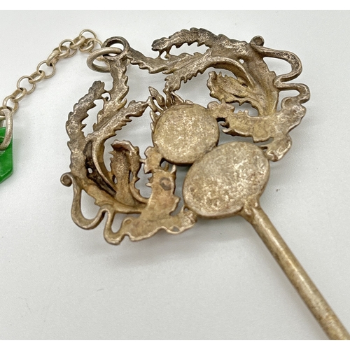 1145 - A Chinese white metal hair pin set with apple green jade cabochons. Approx. 17cm long.