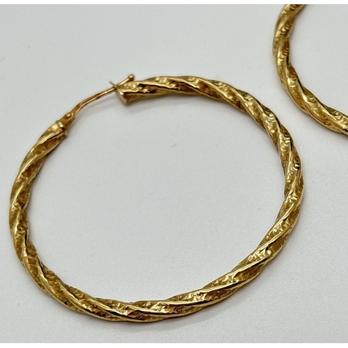 2 - A large pair of 9ct gold twist design hoop earrings. Gold mark to posts. Approx. 4.5cm across. Total... 