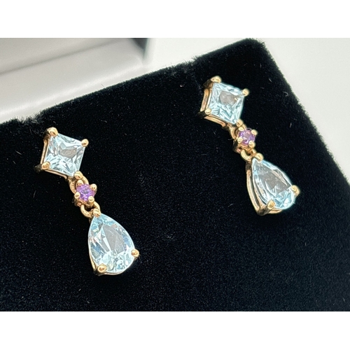 6 - A pair of 9ct gold blue topaz and amethyst set drop earrings. Each set with a square cut and a teard... 