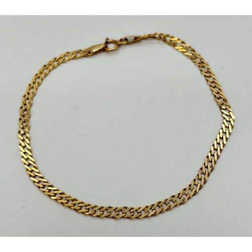 11 - A 9ct gold 7 inch double curb chain bracelet with spring ring  clasp. Gold marks to fixing and clasp... 