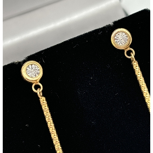 16 - A pair of 9ct yellow and white gold vintage style drop earrings. Circular stud, set with illusion de... 