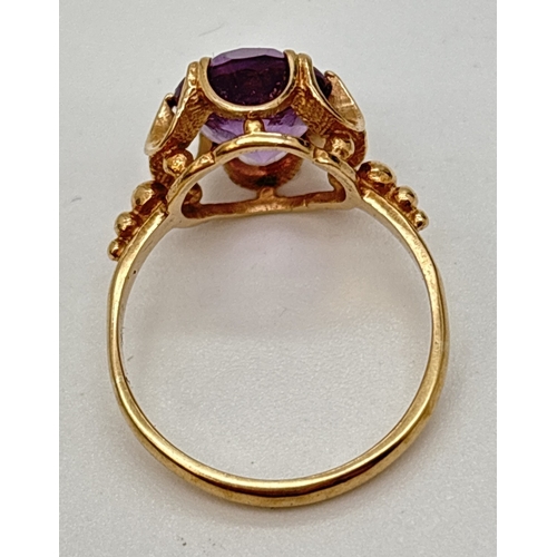 18 - A vintage 9ct gold amethyst set ring with central oval cut amethyst in a high scallop edge mount. St... 